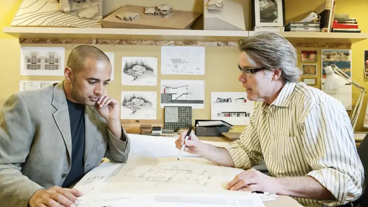 Two men reviewing drawings together in a design office