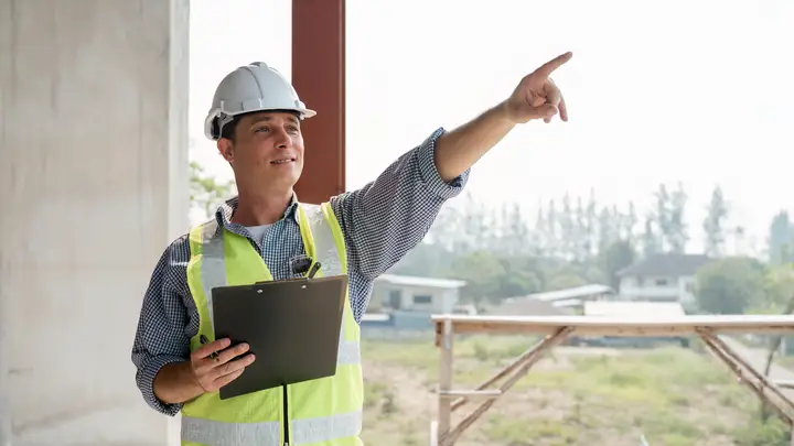 Supervisor with a clipboard pointing out something on site