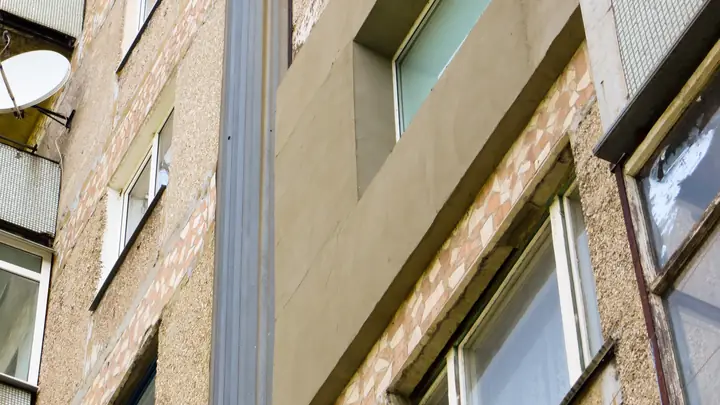 Close-up of a weathered brick apartment block facade with windows