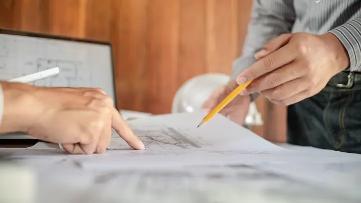 Hands pointing at a drawing with a pencil