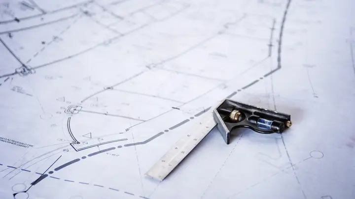 Combination square resting on a technical drawing