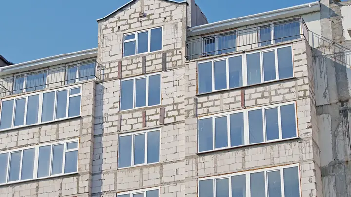 Unfinished blockwork apartment building with new windows