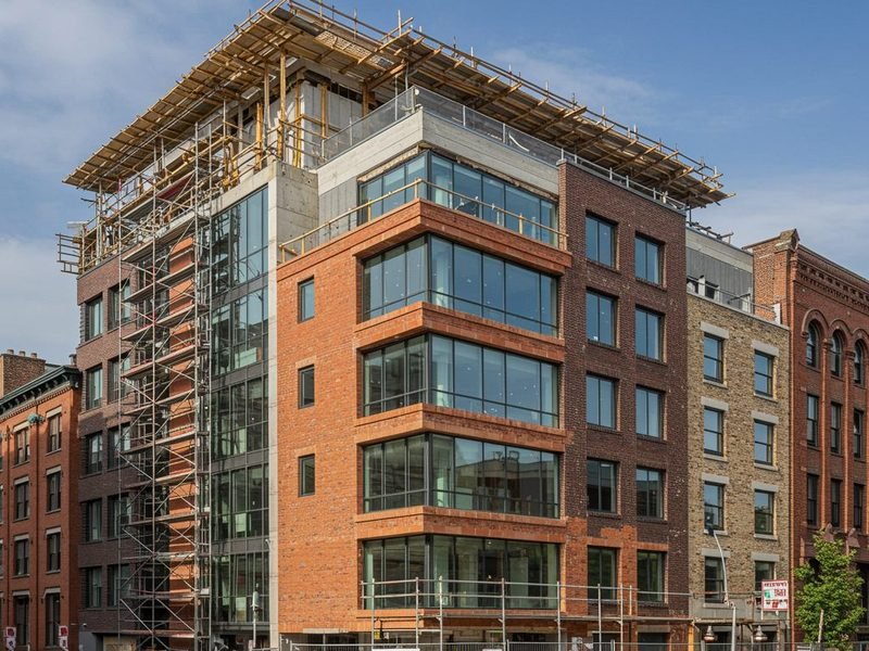 Brick and glass corner building nearing completion